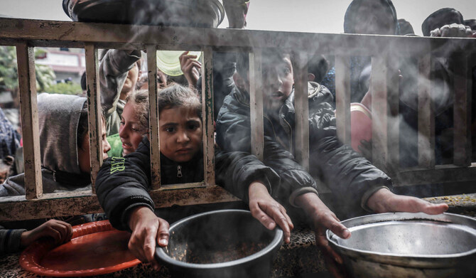 Displaced Palestinian children gather to receive food at a government school in Rafah in the southern Gaza Strip on February 19, 2024, amid the ongoing battles between Israel and Hamas. (AFP/File)
