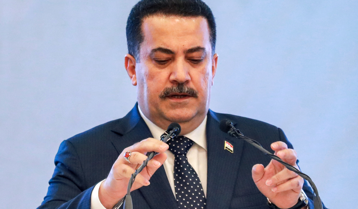 Iraq's Prime Minister Mohammed Shia al-Sudani adjusts his microphones before speaking during an event in Baghdad on May 3, 2024. (AFP)