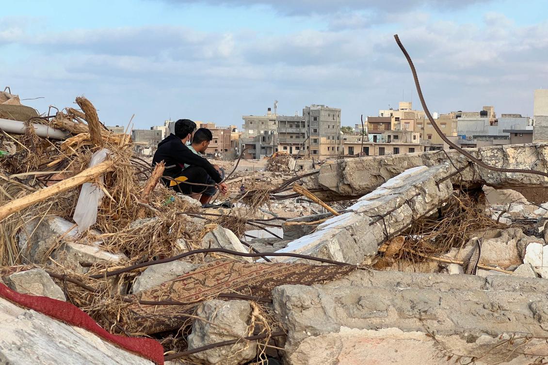 People sit among the rubble in Libya's eastern city of Derna on September 20, 2023. (AFP)