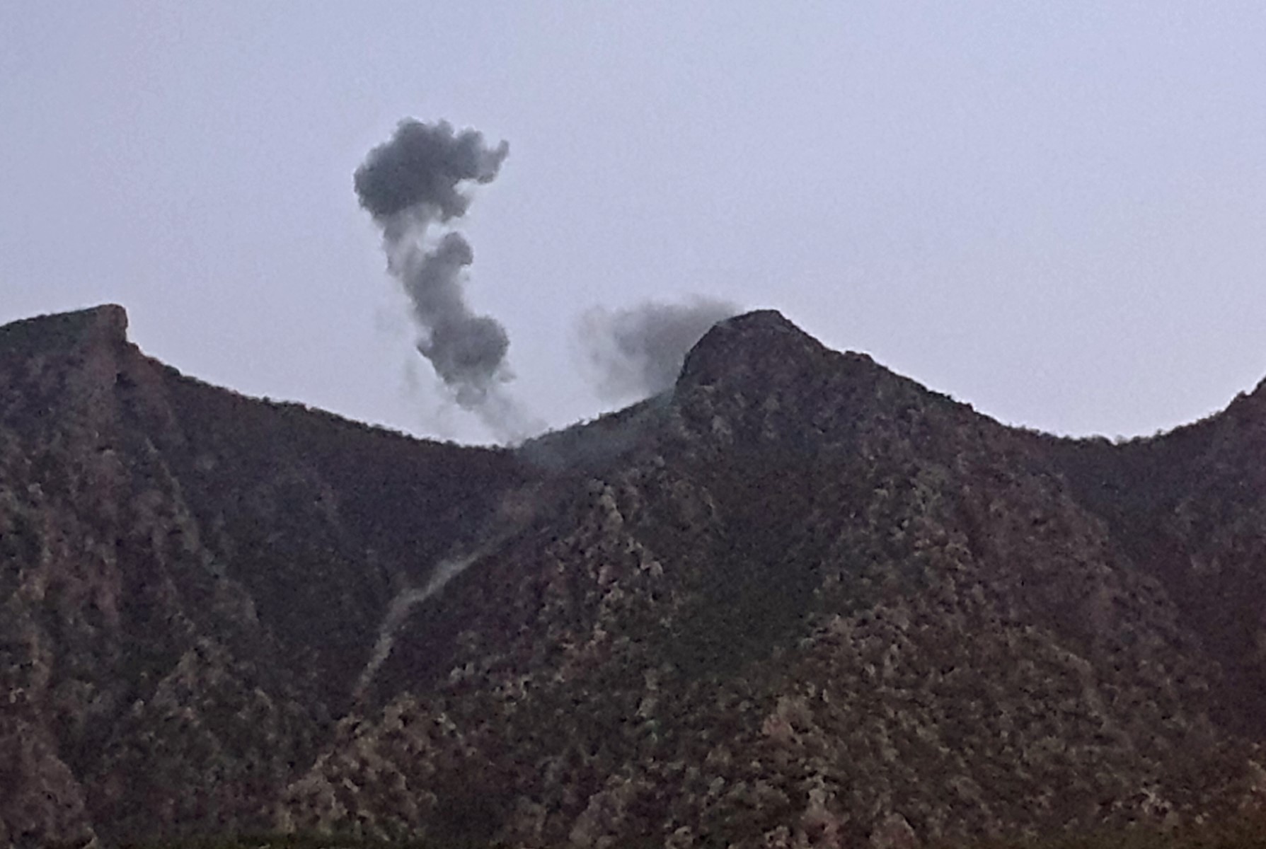A picture taken on April 19, 2022 shows smoke billowing from behind the mountains of Matin (Jabal Matin) in the town of Chiladze following a Turkish offensive targeting rebels in the northern Iraqi Kurdish autonomous region. (AFP)