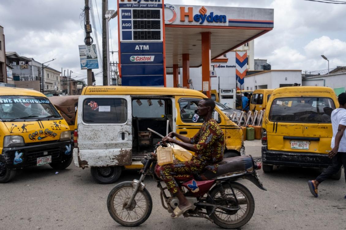 A man holds jerrycans as he rides his motorbike past a fuel station in Lagos, on September 4, 2024. (AFP)