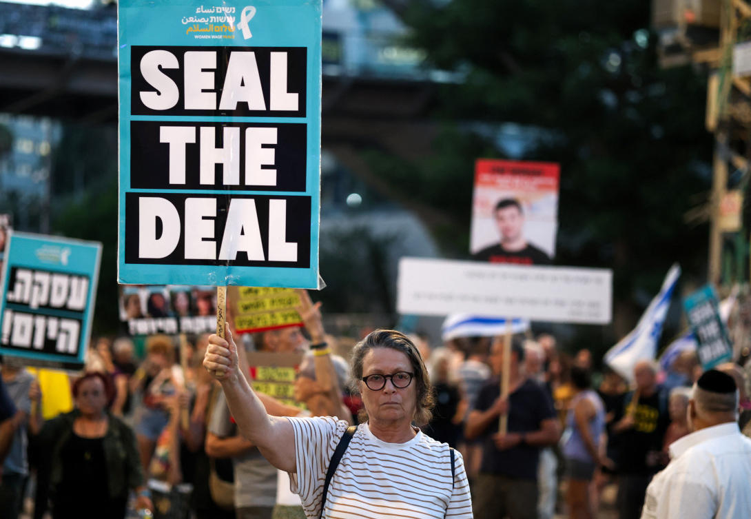 A woman holds a sign as people attend a protest against the government and to show support for the hostages who were kidnapped during the deadly October 7 attack, in Tel Aviv on Sept. 8, 2024. (Reuters)