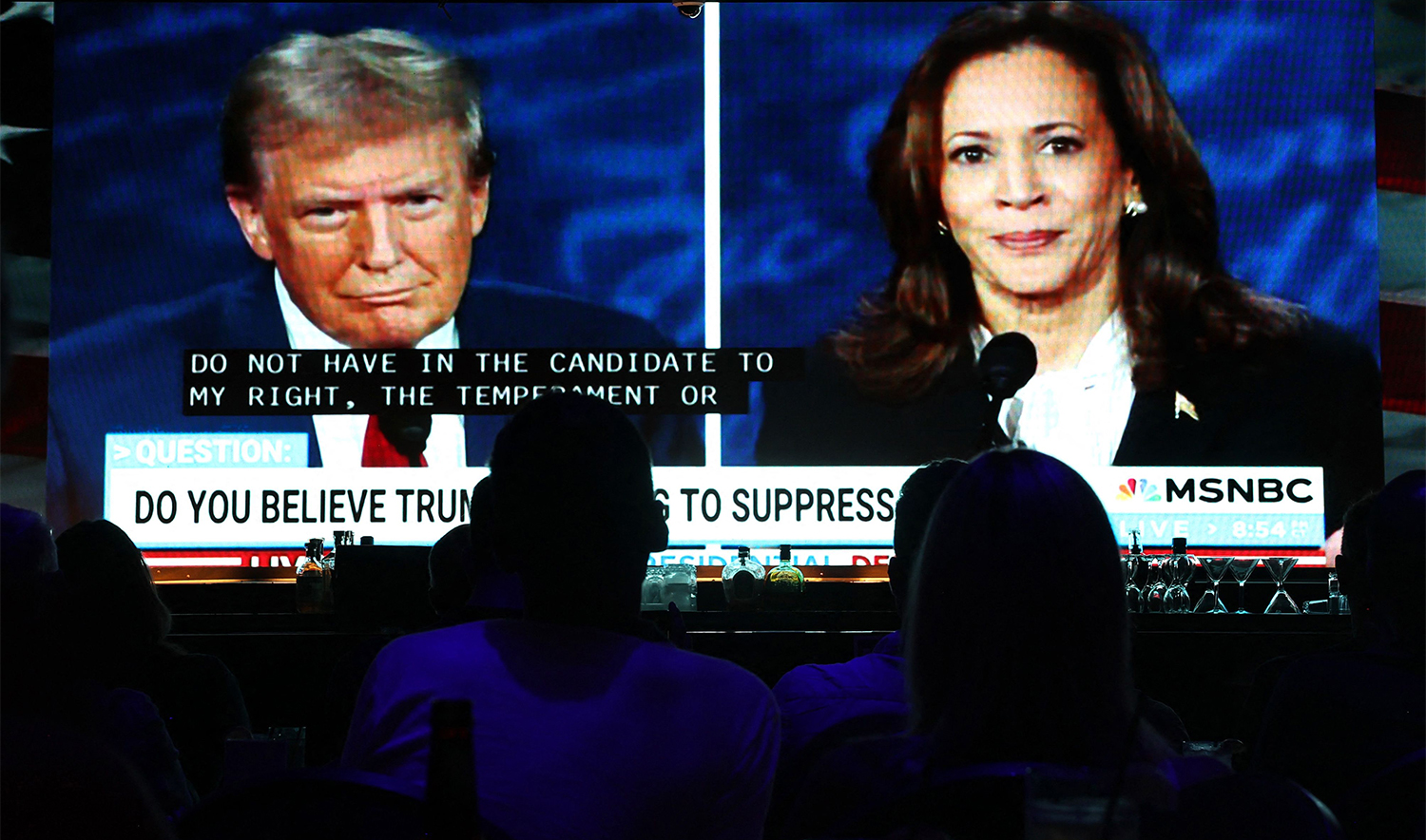 People watch the ABC News presidential debate between Democratic presidential nominee, U.S. Vice President Kamala Harris and Republican presidential nominee, former U.S. President Donald Trump at a debate watch party in West Hollywood, California, on September 10, 2024. (AFP)