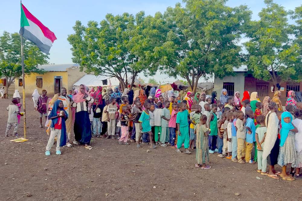 Displaced Sudanese queue to receive food portions at their makeshift camp in the eastern city of Gedaref on Sept. 9, 2024. (AFP)
