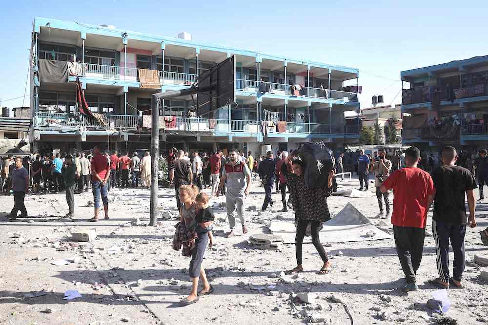 Palestinians walk in the courtyard UN’s Al-Jawni Preparatory Boys School in central Gaza’s Nuseirat refugee camp after an Israeli air strike hit the site on Sept. 11, 2024. (AFP)