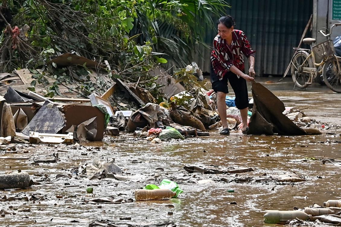 A resident cleans up on a street after flood waters receded in Hanoi on Sept. 13, 2024. Yagi was the strongest typhoon to hit the Southeast Asian country in decades. (AFP)
