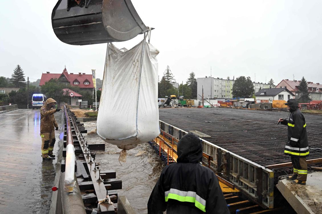 Firefighters place sand bags on the banks of the swollen Biala river in Glucholazy, southern Poland, on September 14, 2024, as Central Europe faces heavy rainfall expected to cause floods. (AFP)