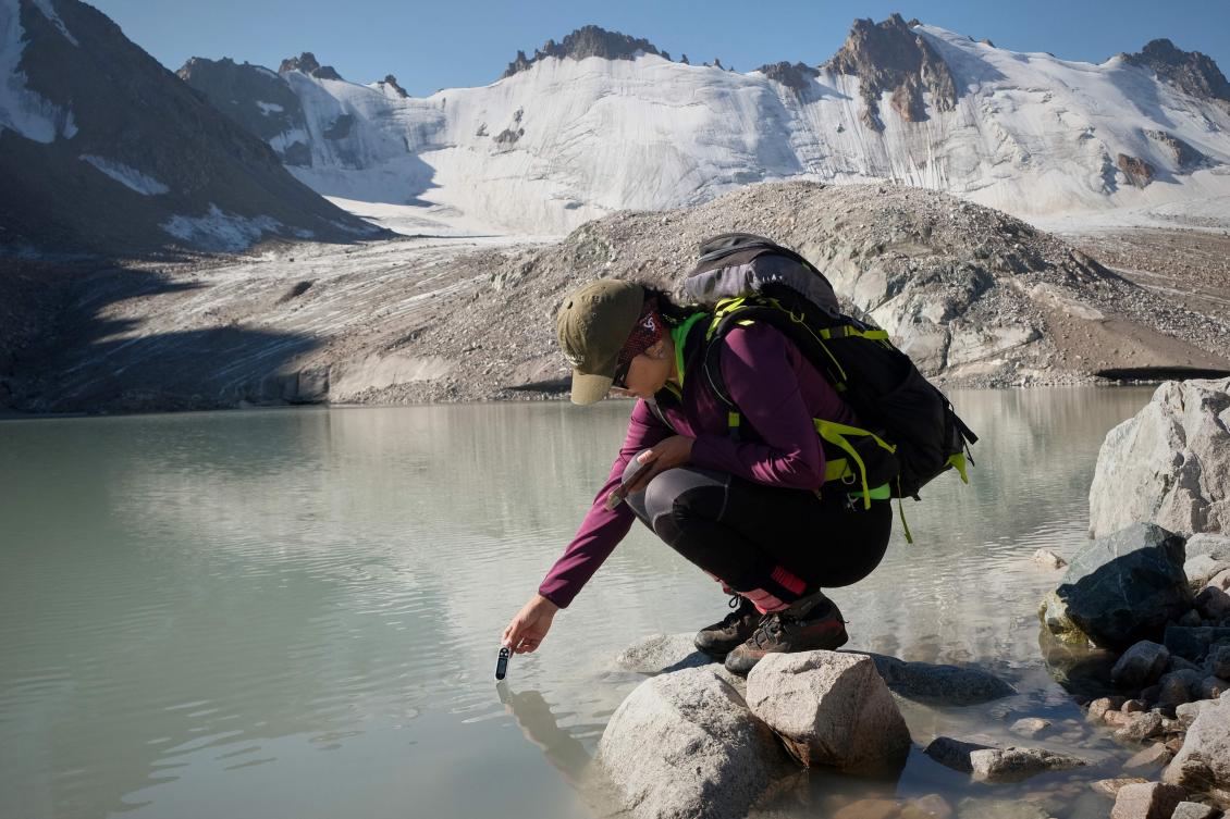 Glaciologist Gulbara Omorova takes measurements in a lake of melted water in the Tian Shan mountain range on July 8, 2024. (AFP)
