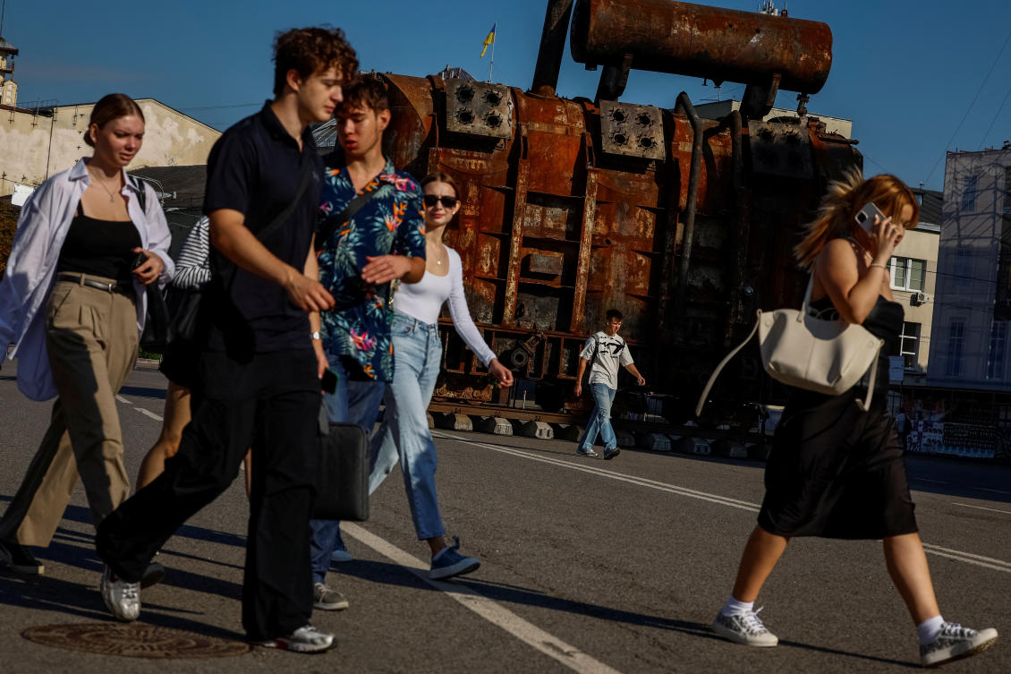People walk past an installation with a power transformer, damaged by a Russian military strike, in the city center, amid Russia's attack on Ukraine, in Kyiv. (Reuters)