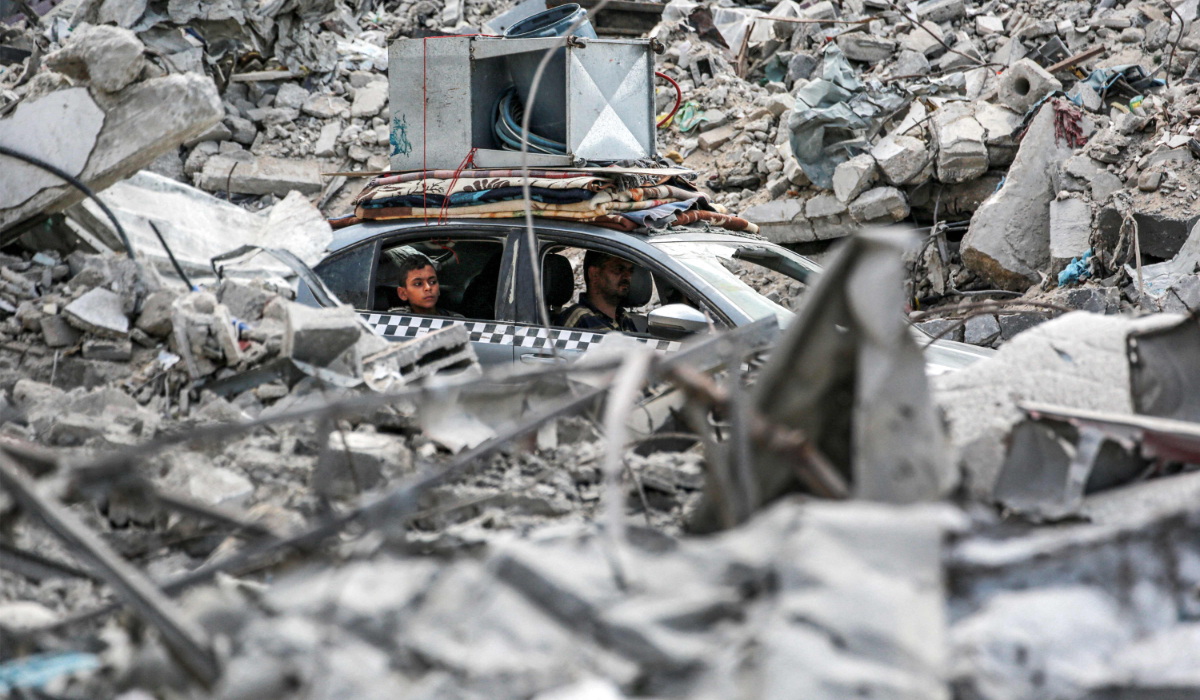 A vehicle moves past the rubble of collapsed buildings in Khan Yunis in the southern Gaza Strip on September 16, 2024, amid the ongoing war in the Palestinian territory between Israel and Hamas. (AFP)