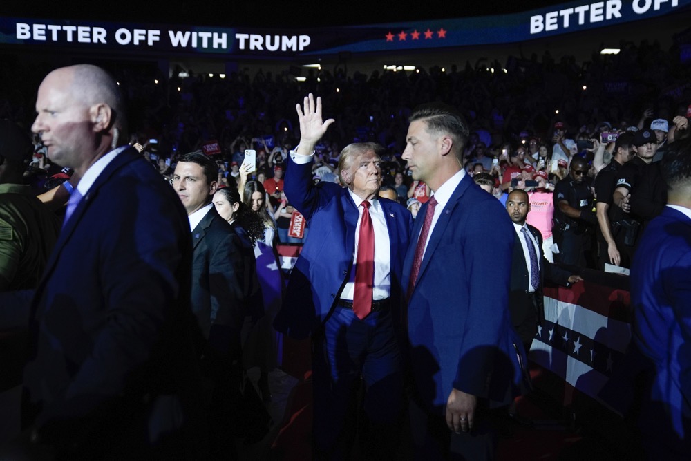 Former US President Donald Trump waves to supporters during his arrival at a town hall event at the Dort Financial Center, Tuesday, Sept. 17, 2024, in Flint, Mich. (AP)