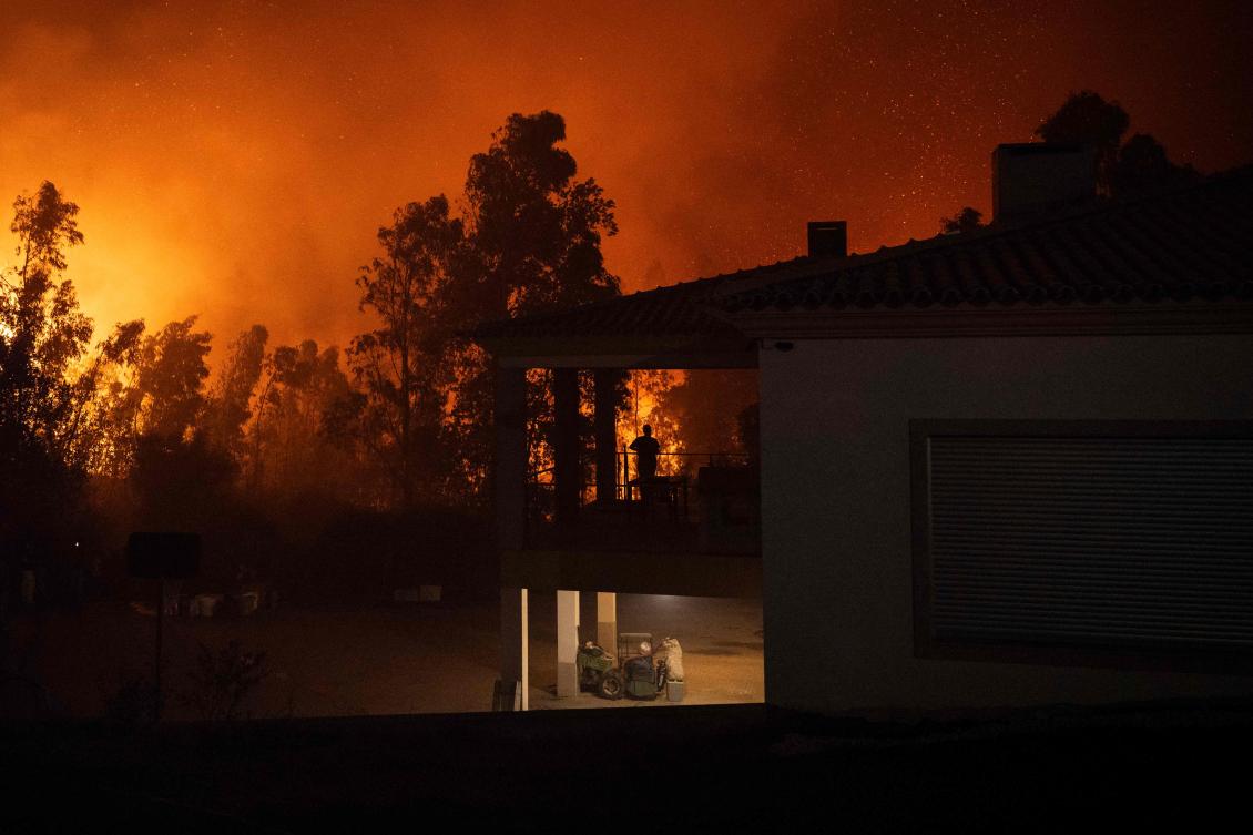 A silhouette of a woman watching a wildfire is pictured as it approaches Veiga village in Agueda, Aveiro on September 17, 2024.(AFP)