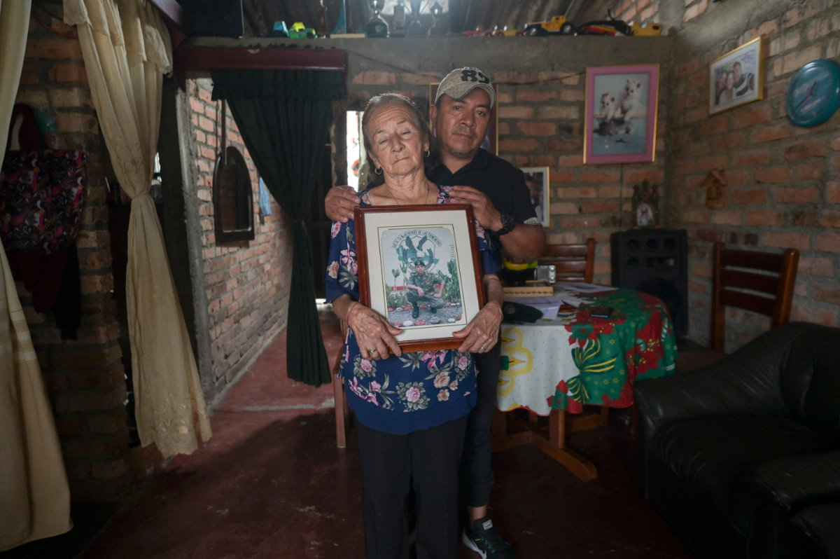 Otilia Ante (L) and Arbey, mother and brother of retired Colombian military officer Alexander Ante, pose with a picture of Alexander at their home in Popayan, Cauca department, Colombia, on September 12, 2024. (AFP)