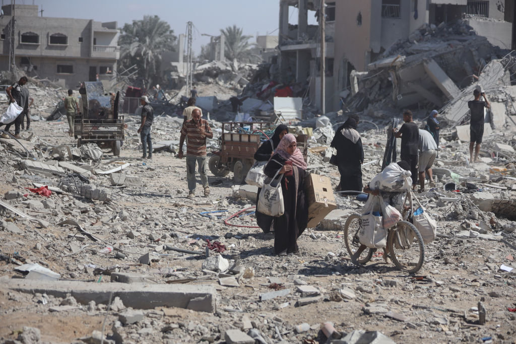 Palestinians collect their belongings and inspect the destruction caused by Israeli airstrikes in eastern Deir al-Balah in central Gaza Strip on August 29, 2024. (NurPhoto via Getty Images)
