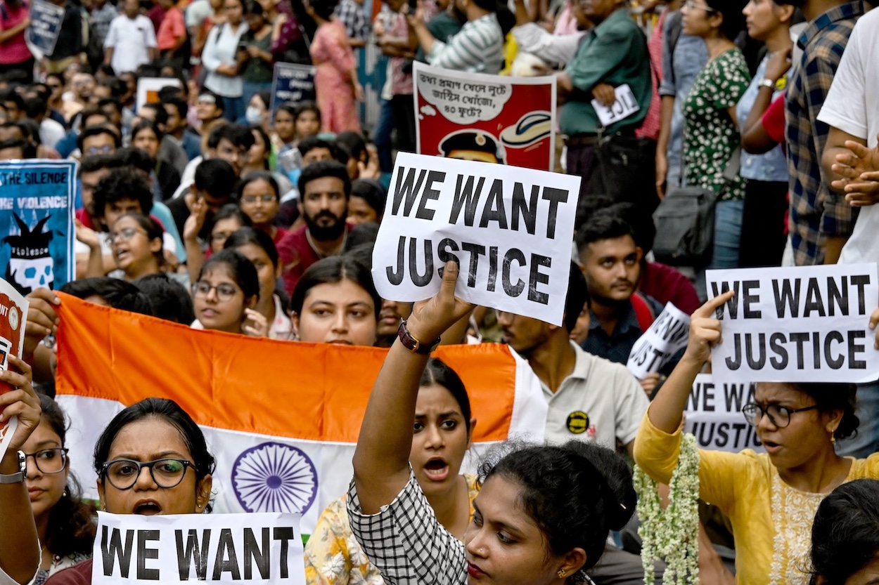 Junior doctors carry India’s national flag and hold placards during a protest to demand accountability over the rape and murder of a female medic, in Kolkata. (File/AFP)