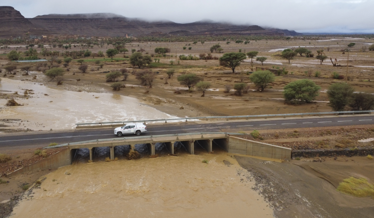 A car drives through a bridge as flood water caused by heavy rainfall streams, in Tazarine, Zagora, southern Morocco, Sunday, Sept. 8, 2024. (AP)