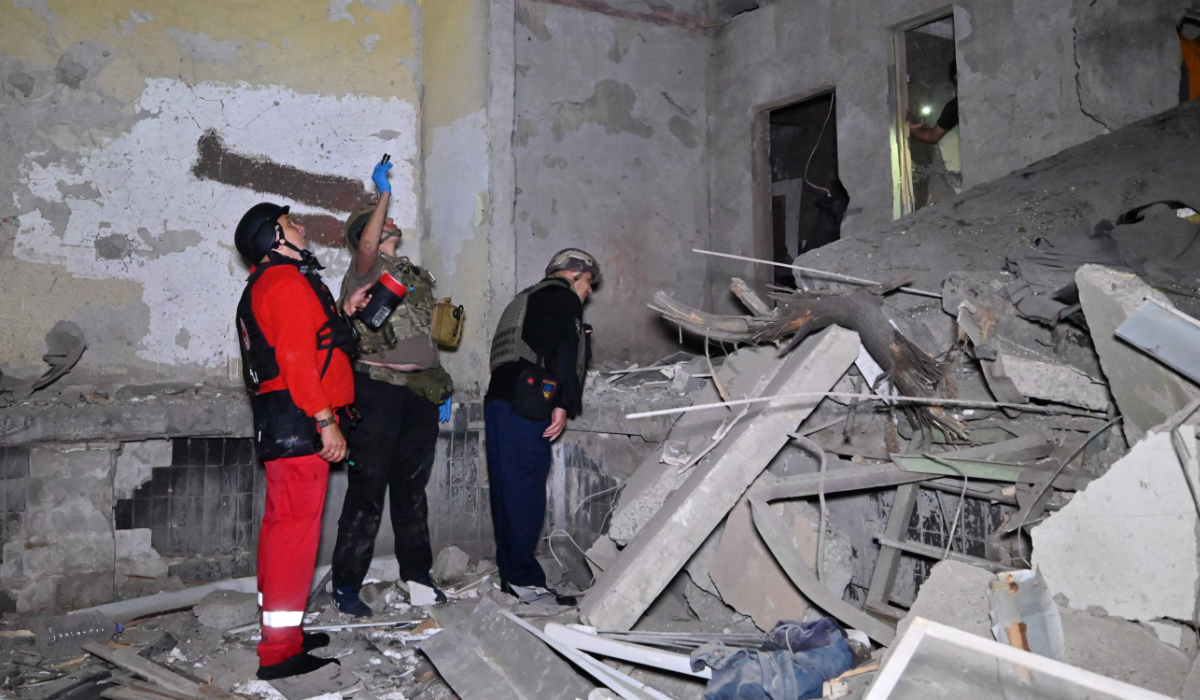 Ukrainian officers inspect damage to a residential building following a missile attack in Kharkiv. (AFP)