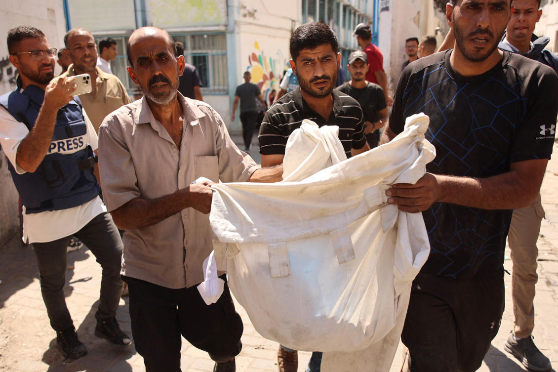Palestinians transport a body from the site of an Israeli strike on a school housing displaced Palestinians in Gaza City's Zaytoun neighbourhood on September 21, 2024. (AFP)