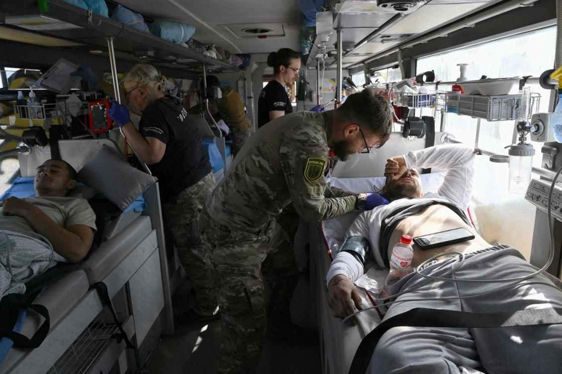 Paramedics from Ukraine’s Hospitallers organisation check on servicemen wounded in battles in the Donetsk region, now on a medical evacuation bus in an undisclosed location, as they are driven to a bigger hospital on September 23, 2024, amid the Russian invasion of Ukraine. (AFP)