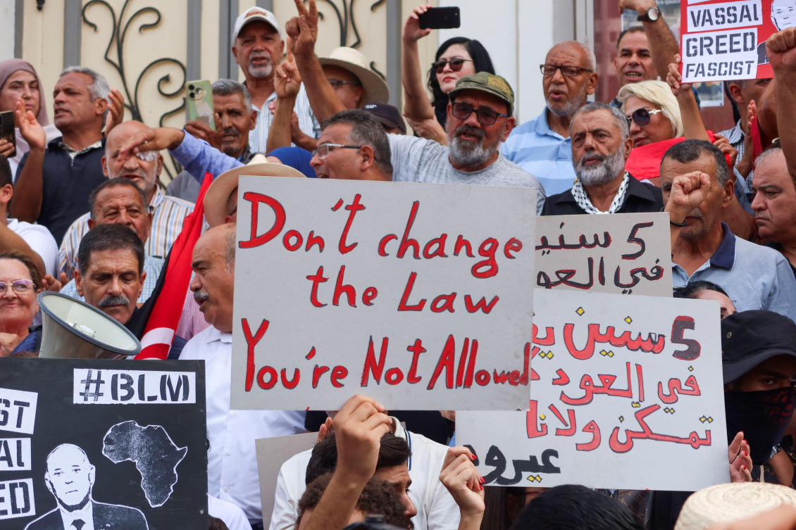 Members of civil society groups and opposition parties carry banners during a protest against Tunisia's President Kais Saied in Tunis, Tunisia. (Reuters)