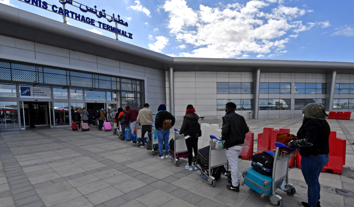 Migrants arrive at Tunis-Carthage International airport on March 7, 2023 as they prepare to leave Tunis on a repatriation flight. (AFP)