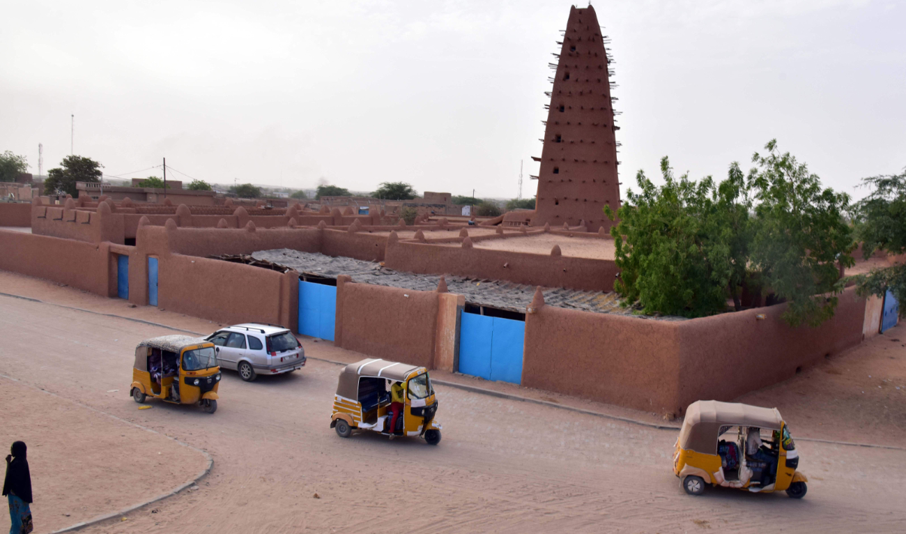 Three-wheelers drive past an earthen mud mosque in Agadez in northern Niger. (AFP/File)