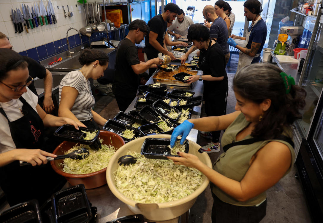 Josephine Abou Abdo, one of the founders of non-profit organization ‘Nation Station’, prepares meals with volunteers to be distributed for people who were displaced due to ongoing hostilities between Hezbollah and Israeli forces, in Beirut, Lebanon September 26, 2024. (REUTERS)