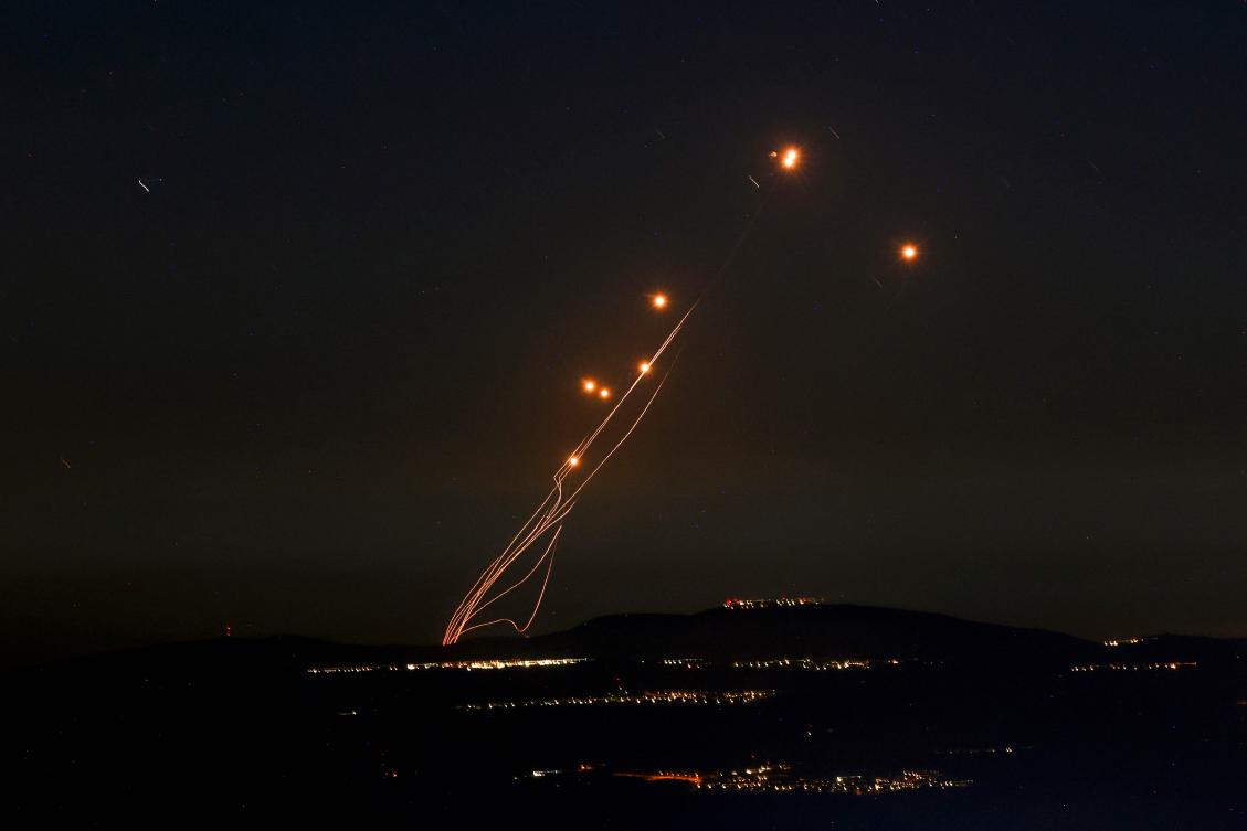 Rockets fired from southern Lebanon are intercepted by Israel’s Iron Dome air defense system over the Upper Galilee region in northern Israel on Sept. 27, 2024. (AFP)