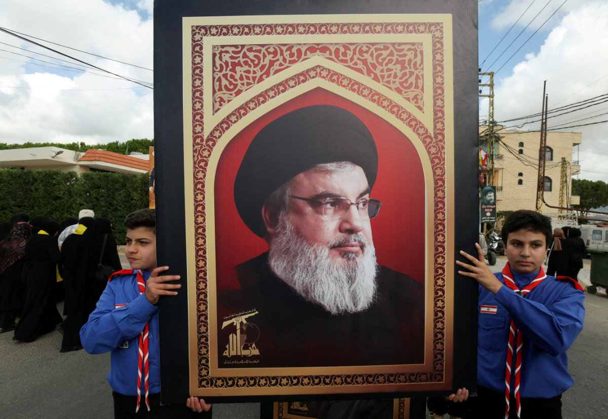 Boys scouts carry a picture of Hezbollah leader Sayyed Hassan Nasrallah during a funeral for a fighter killed in an Israeli pager attack in Kfar Melki, Lebanon, on September 19, 2024. (REUTERS)