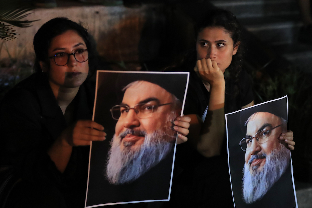 Lebanese and Palestinian women hold portraits of Hezbollah leader Sayyed Hassan Nasrallah during protest in the southern port city of Sidon, Lebanon, Saturday, Sept. 28, 2024. (AP)