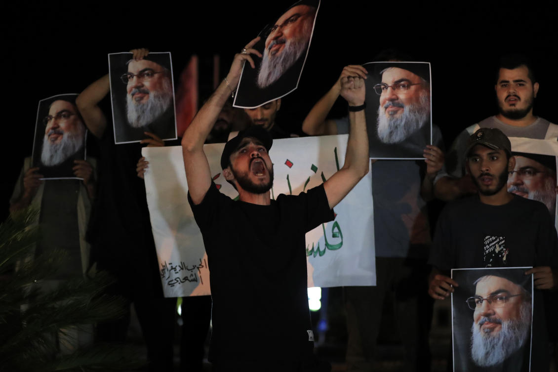 Lebanese and Palestinian men hold portraits of Hezbollah leader Sayyed Hassan Nasrallah, as they shout slogans during a protest in the southern port city of Sidon, Lebanon. (File/AP)