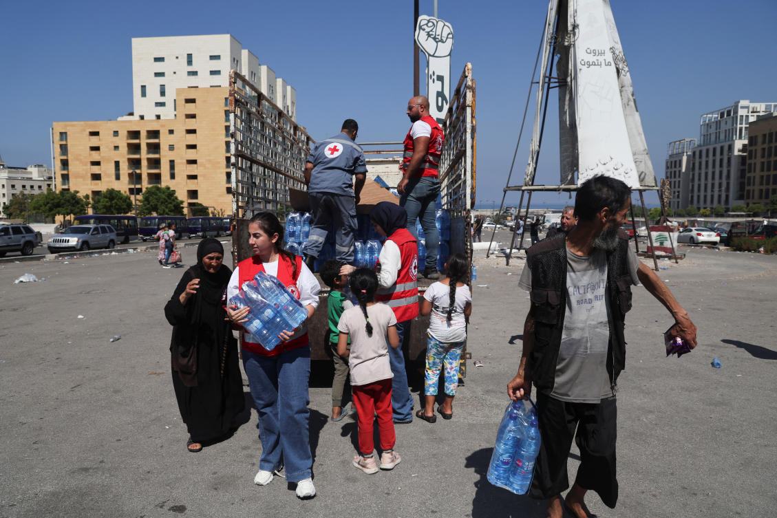 Displaced families receive water and food after fleeing the overnight Israeli strikes, amid ongoing hostilities between Hezbollah and Israeli forces, in southern Beirut, in Lebanon September 28, 2024. (Reuters)