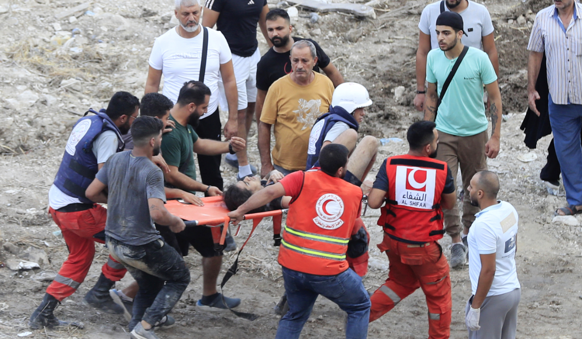 Rescue workers carry a man who was injured after an Israeli airstrike hit two adjacent buildings, in Ain el-Delb neighbourhood east of the southern port city of Sidon, Lebanon, Sunday, Sept. 29, 2024. (AP)