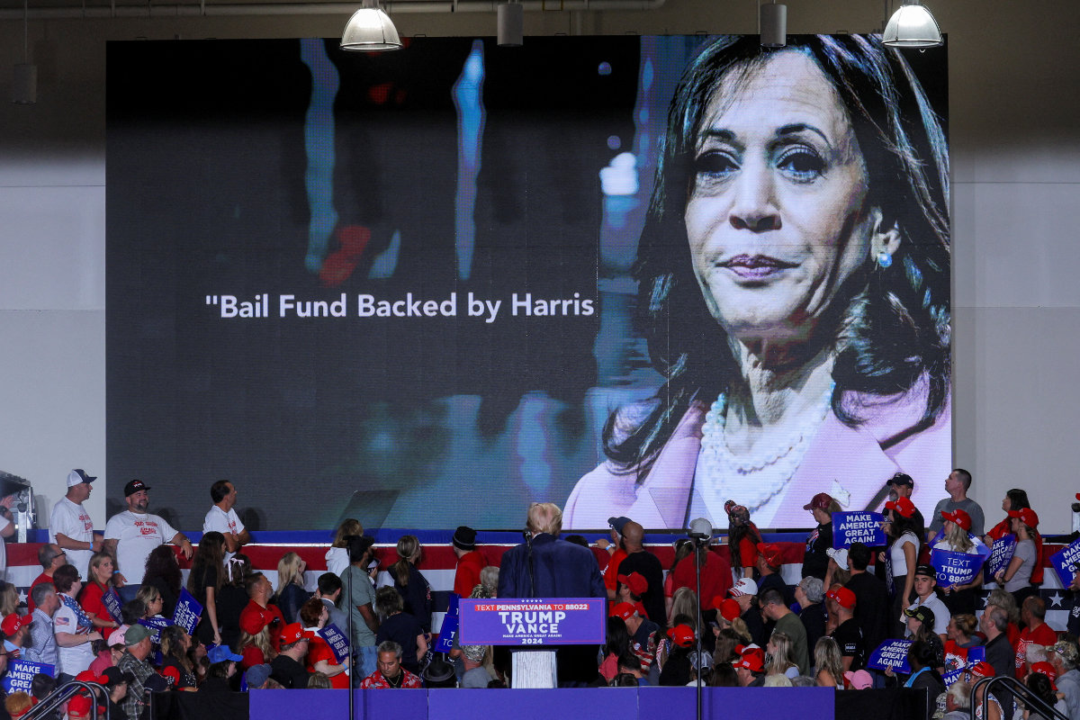 Republican presidential nominee former US President Donald Trump watches a campaign video attacking Democratic presidential nominee US Vice President Kamala Harris, during a campaign rally in Erie, Pennsylvania, on September 29, 2024. (REUTERS)