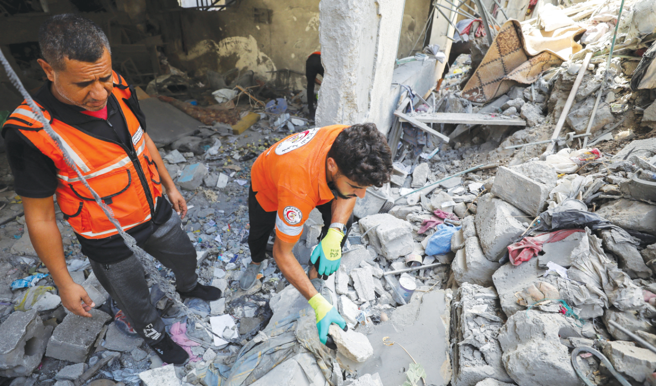 Palestinian Civil Defense members work at the site of an Israeli airstrike in Gaza City. (Reuters)