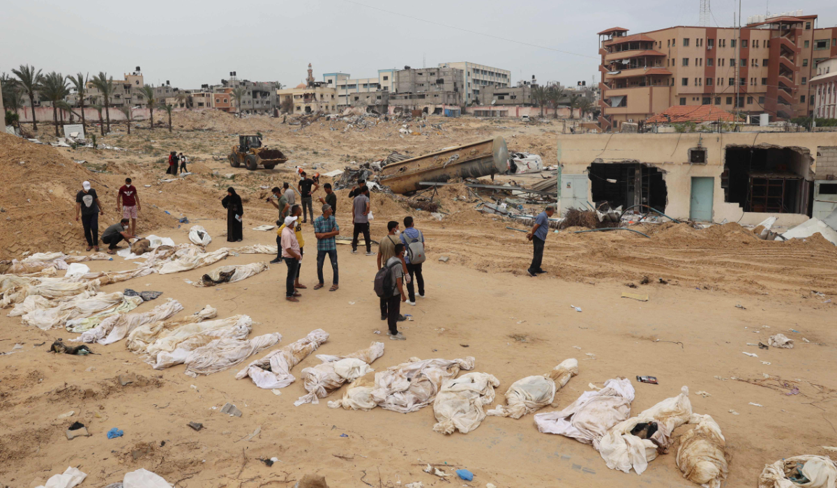 People gather near bodies lined up for identification after they were unearthed from a mass grave found in the Nasser Medical Complex in the southern Gaza Strip on April 25, 2024, amid the ongoing conflict between Israel and the Palestinian militant group Hamas. (AFP)