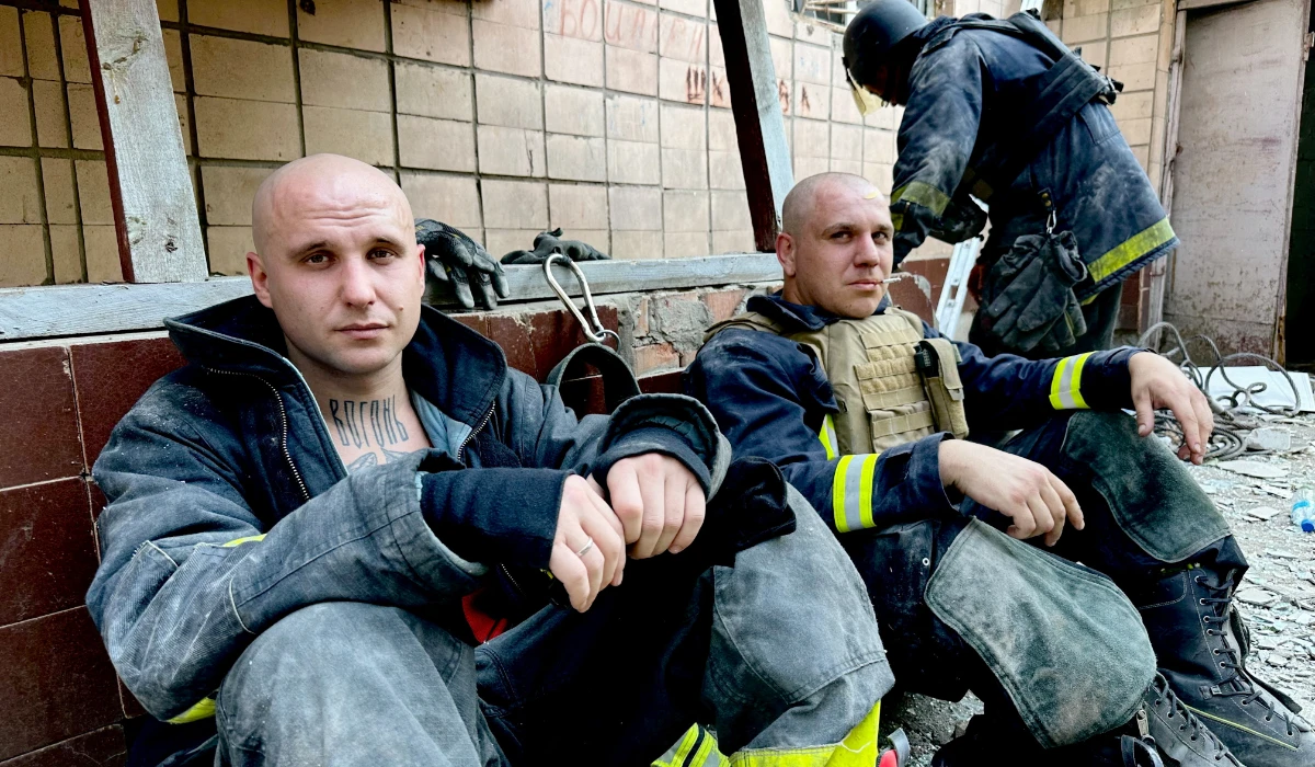 Emergency workers rest near the site where a hotel was hit by a missile in Kramatorsk, Donetsk region, in Ukraine. (REUTERS)
