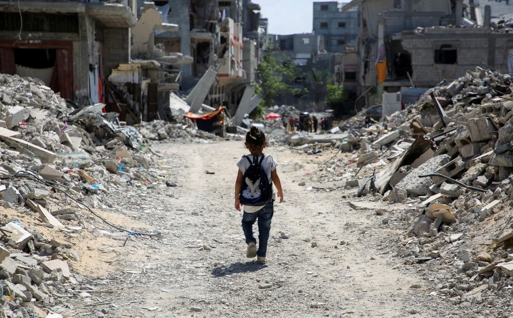A Palestinian student walks home after attending a class in a tent set up on the rubble of the house of teacher Israa Abu Mustafa, Khan Younis, southern Gaza Strip, Sept. 4, 2024. (Reuters)