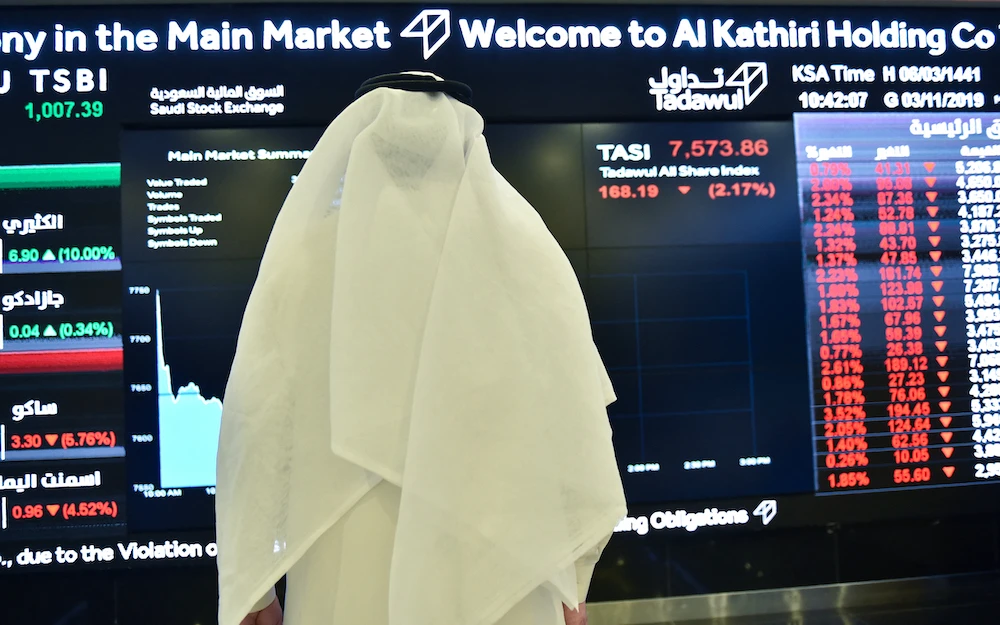 A Saudi man monitors an exchange board at the Stock Exchange Market (Tadawul) bourse in Riyadh. File/AFP