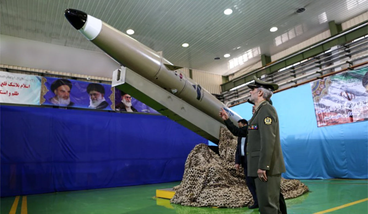 A handout picture released by Iran's Defence Ministry on August 13, 2018 shows Defence Minister, Brigadier General Amir Hatami, standing by the next generation short-range ballistic missile "Fateh Mobin", during an unveiling ceremony in the capital Tehran. (AFP)