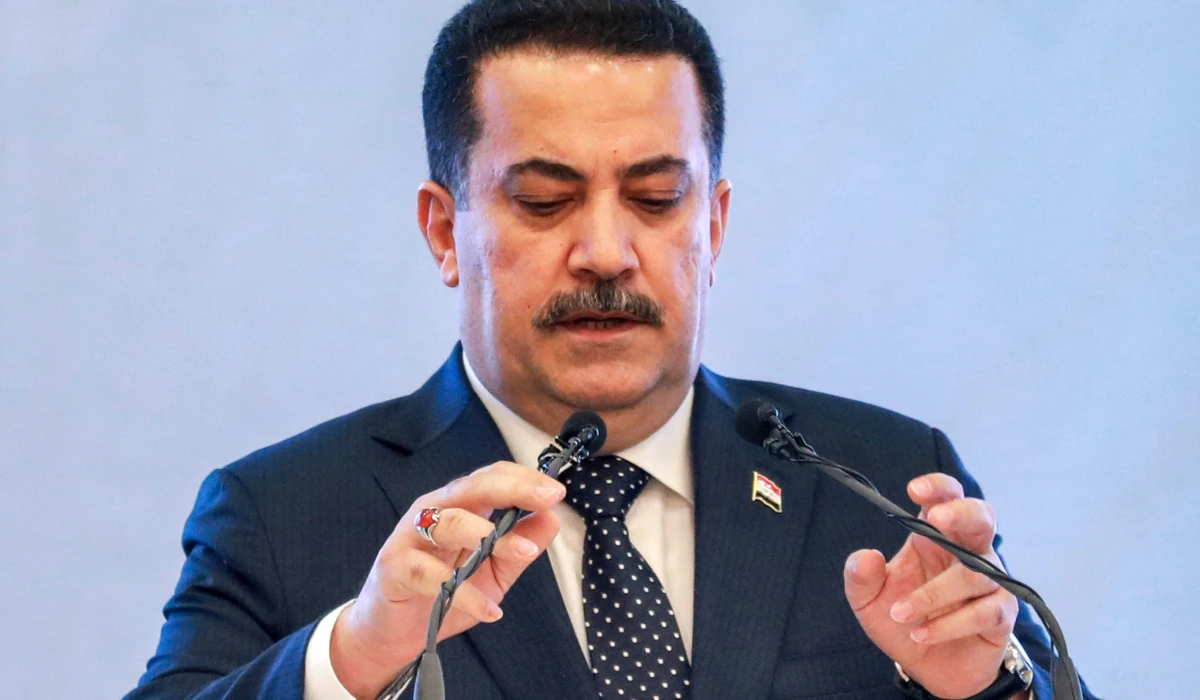 Iraq's Prime Minister Mohammed Shia al-Sudani adjusts his microphones before speaking during an event in Baghdad on May 3, 2024. (AFP)