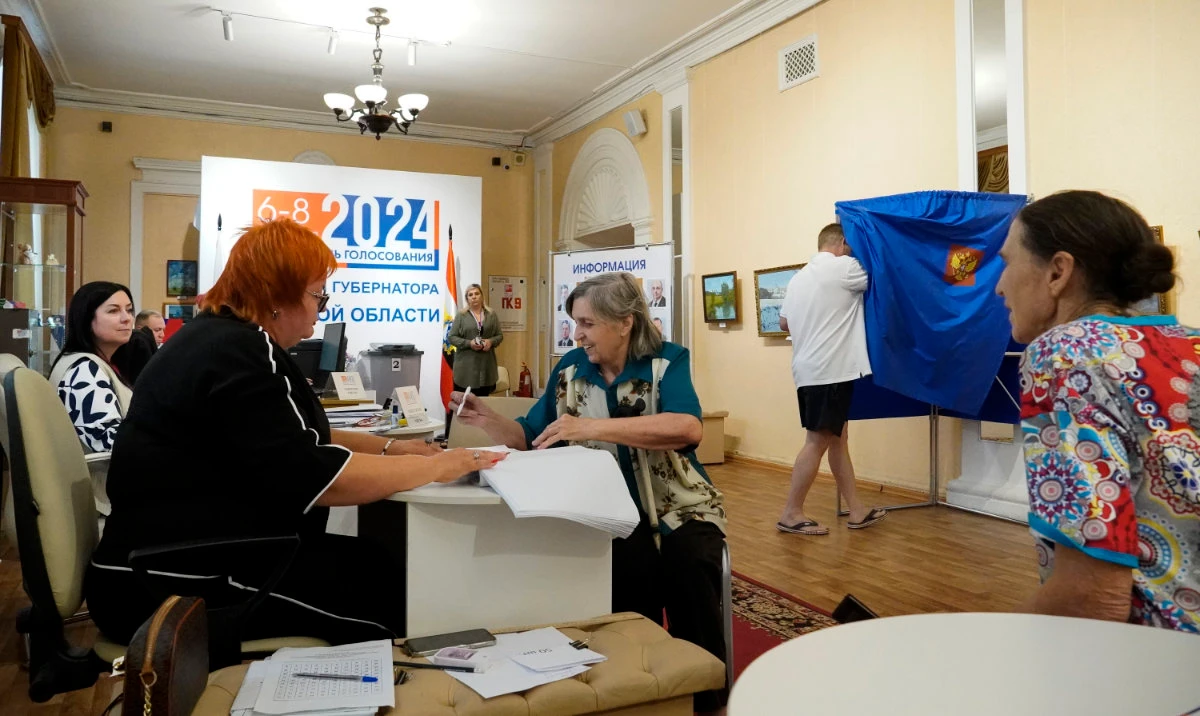 A woman receives her ballot at a polling station during the three-day Kursk region governor election, in Kursk, Russia, Sunday, Sept. 8, 2024. (AP)