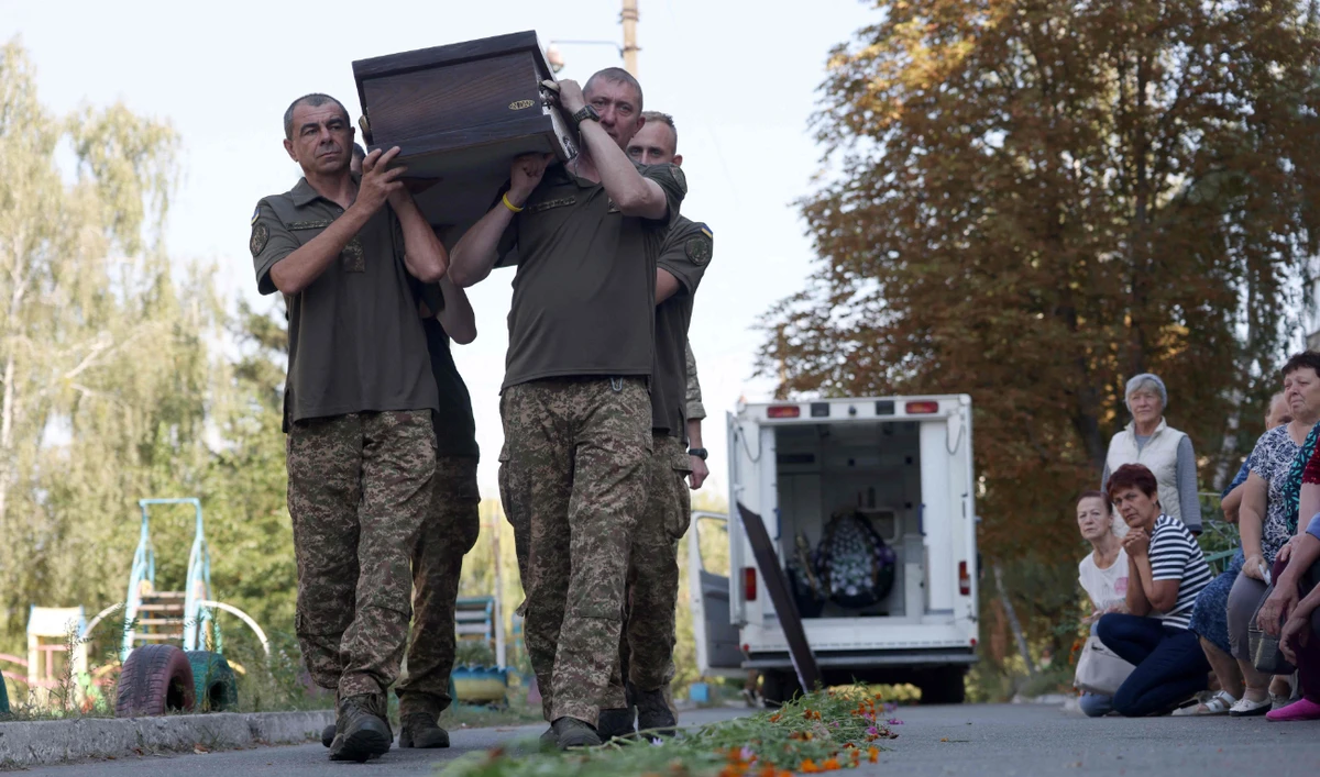 Ukrainian servicemen carry the coffin of their comrade in Bucha, amid Russia’s war with Kyiv. (AFP/File)