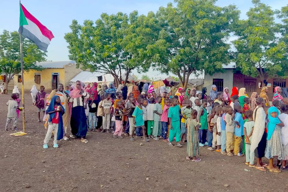 Displaced Sudanese queue to receive food portions at their makeshift camp in the eastern city of Gedaref on Sept. 9, 2024. (AFP)