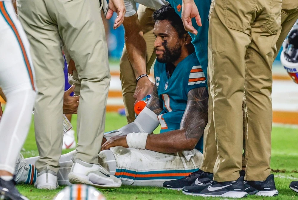 Miami Dolphins quarterback Tua Tagovailoa (1) sits on the field as he is attended to after an injury during the game against the Buffalo Bills. (Miami Herald/AP)