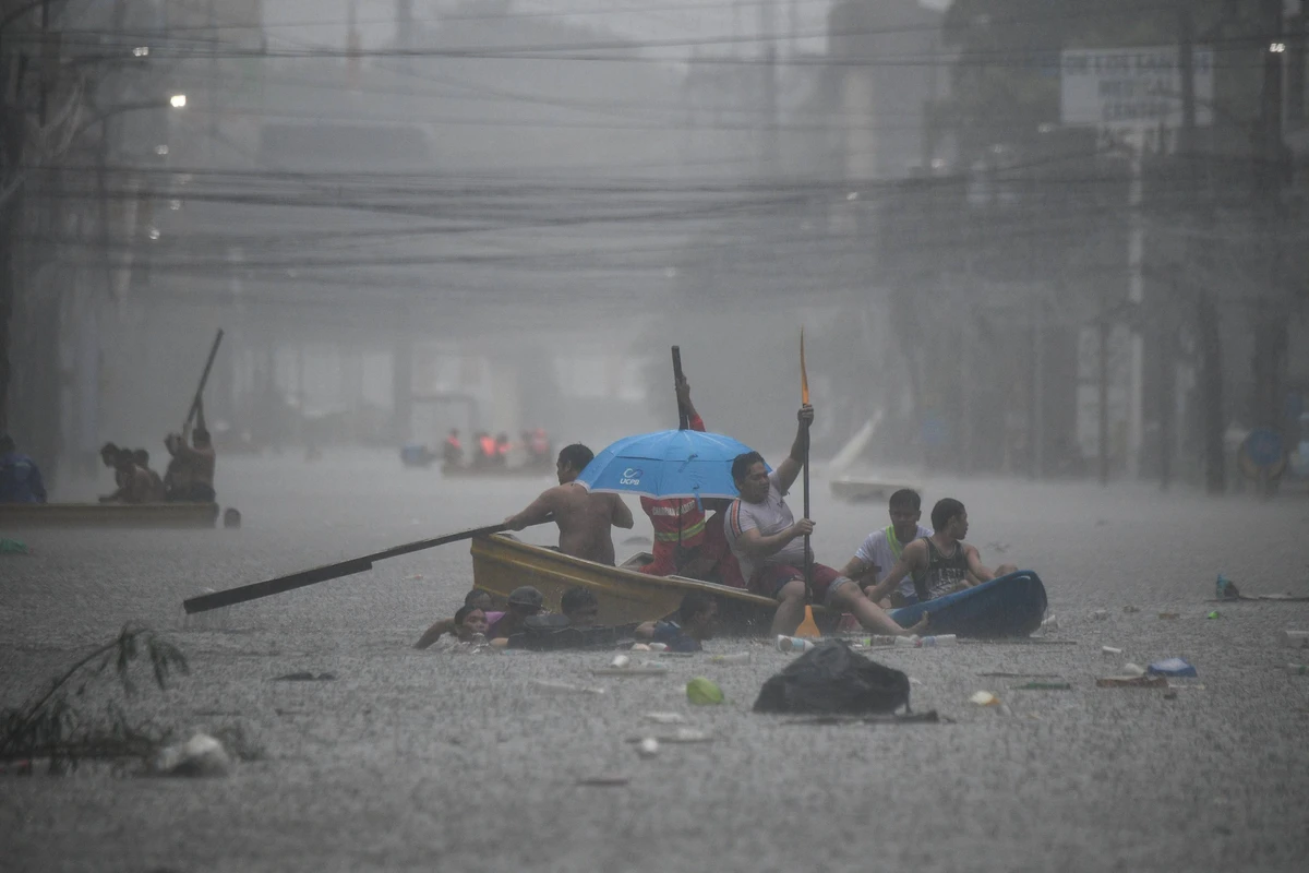 Rescuers paddle their boats along a flooded street in Manila amid heavy rains brought by Typhoon Gaemi. (File/AFP)