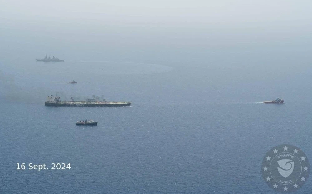 Tugboats, escorted by military vessels, tow the damaged Greek-flagged oil tanker MV Sounion, which has been on fire since Aug. 23, after an attack by Houthis, on the Red Sea, Sept. 16, 2024. (Reuters)