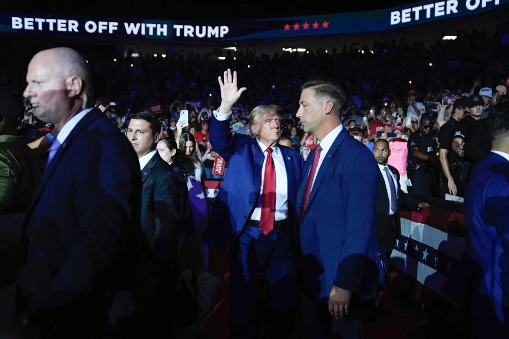 Former US President Donald Trump waves to supporters during his arrival at a town hall event at the Dort Financial Center, Tuesday, Sept. 17, 2024, in Flint, Mich. (AP)