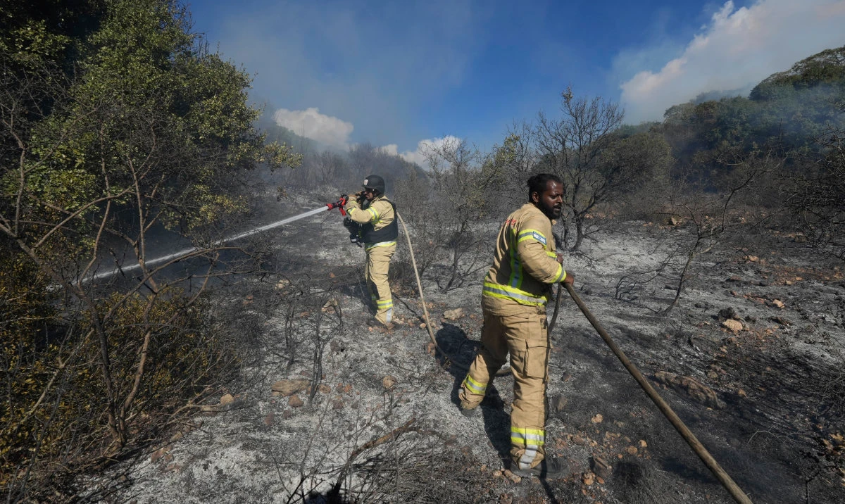 Israeli firefighters work to extinguish a fire after a rocket fired from Lebanon hit an open field in northern Israel, Wednesday, Sept. 18, 2024. (AP)