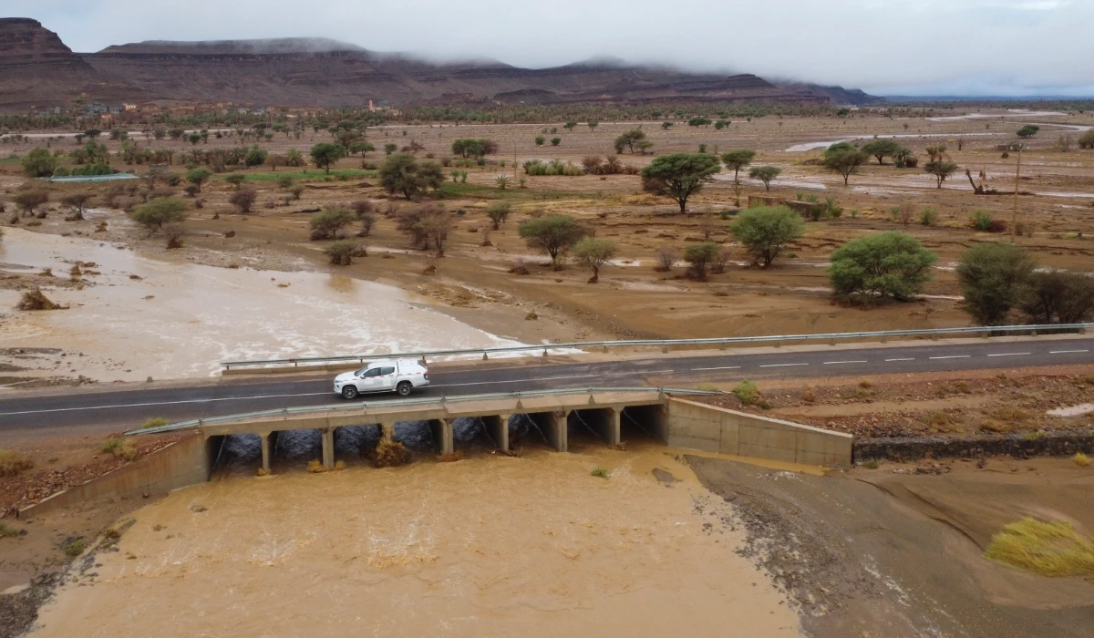 A car drives through a bridge as flood water caused by heavy rainfall streams, in Tazarine, Zagora, southern Morocco, Sunday, Sept. 8, 2024. (AP)